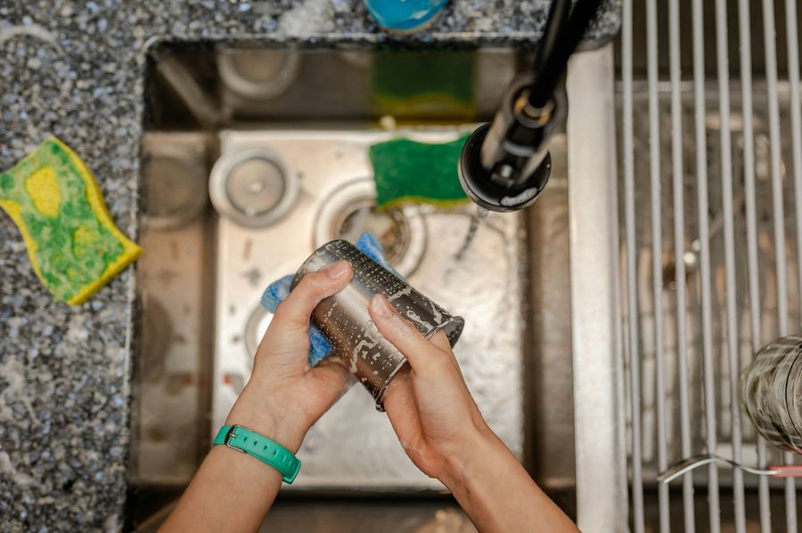 Hands scrubbing a kitchen sink